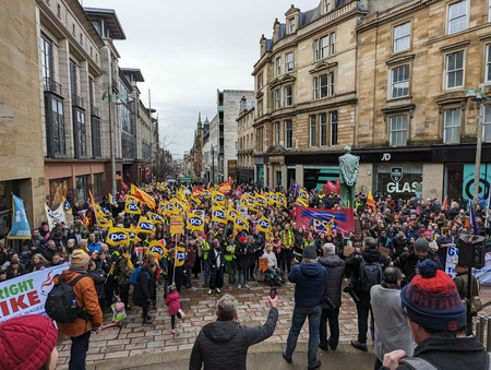 Photo shows large crowd of people holding yellow PCS flags