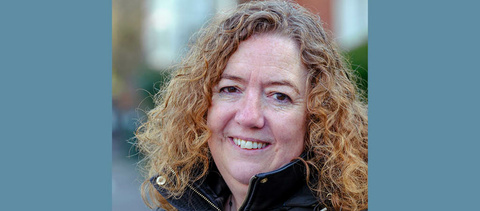 Fran has shoulder-length curly hair and is smiling at the camera - photo credit Jess Hurd